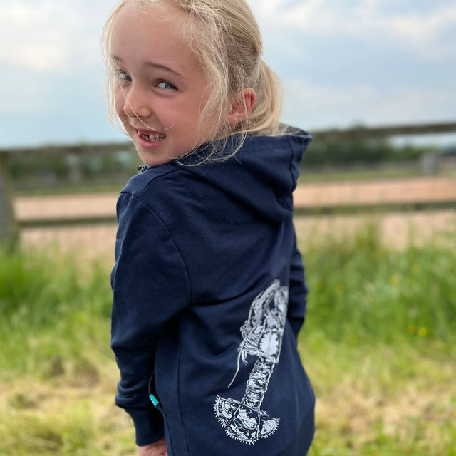 Girl outside wearing a Jellymud Junior Navy Bamboo Hoodie featuring a limited edition print by John Aspden